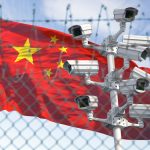 Flag of China behind barbed wire fence and cctv cameras.